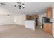 Open living space with a ceiling fan, access to the kitchen, carpet, and a staircase at 104 Big Cliff Ave, North Las Vegas, NV 89031