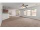 Spacious living room featuring carpet, multiple windows, ceiling fan, and a sliding glass door at 104 Big Cliff Ave, North Las Vegas, NV 89031