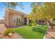 Serene backyard with synthetic grass, flowering shrubs, and a partially covered patio at 10404 Long Leaf Pl, Las Vegas, NV 89134