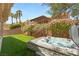 Landscaped backyard featuring a spa with stone accents, manicured bushes, and a grassy area at 10404 Long Leaf Pl, Las Vegas, NV 89134