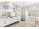 Elegant bathroom featuring marble walls, double vanity, a walk-in shower, and a soaking tub at 10404 Long Leaf Pl, Las Vegas, NV 89134