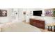 Cozy bedroom with hardwood floors, a dresser with a television, and a view into the ensuite bathroom at 10404 Long Leaf Pl, Las Vegas, NV 89134