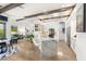 Open kitchen with white cabinets, marble countertops, stainless steel appliances, and breakfast bar seating overlooking living spaces at 10404 Long Leaf Pl, Las Vegas, NV 89134