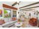 Bright living room featuring exposed-beam ceilings, light-colored hardwood floors, and large windows with outdoor views at 10404 Long Leaf Pl, Las Vegas, NV 89134