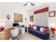 Office with a work station, desk and blue sofa with colorful wall art at 10404 Long Leaf Pl, Las Vegas, NV 89134