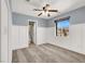 This bedroom features plush carpet, a ceiling fan, a large window, and paneled walls at 10845 Drake Ridge Ave, Las Vegas, NV 89166