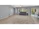 Bright living room with large windows, a comfortable sofa, and neutral carpet flooring at 10845 Drake Ridge Ave, Las Vegas, NV 89166