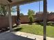 The backyard features a covered patio, lawn, trees, and a block wall for privacy at 11029 Meadow Leaf Ave, Las Vegas, NV 89144