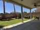 Backyard features a covered patio and ceiling fan, with lawn, palm trees, and roses at 11029 Meadow Leaf Ave, Las Vegas, NV 89144
