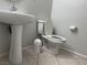 The compact half bathroom features a pedestal sink, toilet, and tiled floors at 11029 Meadow Leaf Ave, Las Vegas, NV 89144