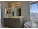 Bathroom with a double vanity, bathtub, and a window at 11029 Meadow Leaf Ave, Las Vegas, NV 89144