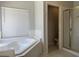 Bright bathroom features a large soaking tub and a separate shower area with glass doors at 11029 Meadow Leaf Ave, Las Vegas, NV 89144