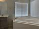Bathroom featuring a soaking tub, neutral tiles and natural light through a window at 11029 Meadow Leaf Ave, Las Vegas, NV 89144
