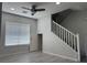Bright living room with a ceiling fan, wood-style flooring, a staircase, and natural light from the window at 11029 Meadow Leaf Ave, Las Vegas, NV 89144