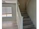 Bright entryway featuring gray wood-look flooring and a staircase with white railings at 11029 Meadow Leaf Ave, Las Vegas, NV 89144