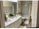 Bright bathroom featuring double sinks, a shower-tub combination, granite countertops and a white wooden cabinet at 11074 Caramel Crest Ct, Las Vegas, NV 89135