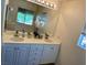 Bright bathroom featuring a double sink vanity with a large mirror and modern fixtures at 11074 Caramel Crest Ct, Las Vegas, NV 89135