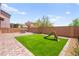 Backyard with artificial turf, a play structure, and a brick-paved seating area at 11274 Civita St, Las Vegas, NV 89141