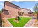 Backyard featuring artificial grass, a playground set, and a brick-paved patio area at 11274 Civita St, Las Vegas, NV 89141