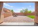 Backyard featuring brick pavers, an outdoor table and chairs, and a grassy area at 11274 Civita St, Las Vegas, NV 89141