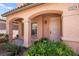 Close-up of a covered front porch with decorative columns, manicured bushes, and a stylish front door at 11274 Civita St, Las Vegas, NV 89141