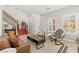Stylish living room with staircase, neutral walls, tiled flooring, and plenty of natural light at 11274 Civita St, Las Vegas, NV 89141