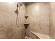 Walk-in shower featuring stylish tile work, built-in shelves, and a comfortable bench at 11274 Civita St, Las Vegas, NV 89141