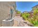 Enclosed backyard with brick pavers, small garden, and an air conditioning unit at 1130 Blissful Plains Ave, North Las Vegas, NV 89086