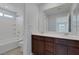Bright bathroom featuring double sinks, a bathtub with white tile surround, and modern fixtures at 1130 Blissful Plains Ave, North Las Vegas, NV 89086