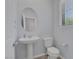 Cozy half bathroom with pedestal sink, round mirror and ample light at 1130 Blissful Plains Ave, North Las Vegas, NV 89086