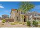 View of the home highlighting the attractive earth tone stucco, brick accents, and low maintenance landscaping at 1130 Blissful Plains Ave, North Las Vegas, NV 89086