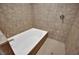 Clean white bathtub inside of a tiled shower/tub offers a comfortable bathing experience at 1190 E Carson Ave, Las Vegas, NV 89101