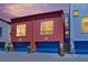 Townhome exterior with colorful metal walls, dark blue garage doors, and green landscaping at 1190 E Carson Ave, Las Vegas, NV 89101
