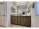 Bathroom with a double sink vanity, decorative mirrors, and neutral finishes for a clean design at 1200 Mission View Ct, Henderson, NV 89002