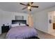 Bedroom with a ceiling fan, bed with plush bedding, and an adjacent bathroom for convenience at 1200 Mission View Ct, Henderson, NV 89002