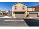 Exterior of townhomes featuring garages, well-manicured desert landscaping, and architecture at 1200 Mission View Ct, Henderson, NV 89002