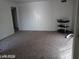 A spacious living room with tan carpet and a metal utility cart on wheels at 1405 Vegas Valley Dr # 360, Las Vegas, NV 89169