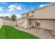 Landscaped backyard with stone patio and green grass offers a serene outdoor space with easy access to the home at 1611 Buffalo Trail Dr, Henderson, NV 89014