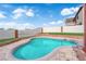 Backyard pool with stone trim surrounded by green grass and a high block wall for privacy and relaxing outdoor enjoyment at 1611 Buffalo Trail Dr, Henderson, NV 89014