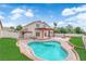 Beautiful backyard with a pool, grassy area, a patio with a pergola, and a built in fire pit for outdoor gatherings at 1611 Buffalo Trail Dr, Henderson, NV 89014