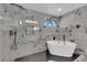 Modern bathroom featuring a soaking tub, black fixtures, and marble-look tile at 1611 Buffalo Trail Dr, Henderson, NV 89014