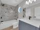 Bathroom featuring marble tile, a blue vanity, a shower/tub, and modern finishes at 1611 Buffalo Trail Dr, Henderson, NV 89014