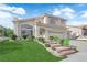 A two-story home with a two-car garage, lush landscaping, and lawn at 1611 Buffalo Trail Dr, Henderson, NV 89014