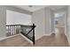Upstairs hallway with wood floors and railing leads to bedrooms, enhancing flow and accessibility throughout the home at 1611 Buffalo Trail Dr, Henderson, NV 89014
