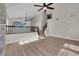 Spacious living room with beautiful hardwood floors, staircase, railing, and a modern ceiling fan at 1611 Buffalo Trail Dr, Henderson, NV 89014