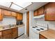 This is a well-lit kitchen, equipped with wood cabinetry, white appliances, and vinyl floors at 1628 Justin Ct # 18, Henderson, NV 89011