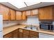 This kitchen features wood cabinets, a stainless steel microwave, and a double basin sink at 1628 Justin Ct # 18, Henderson, NV 89011