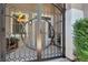 Close-up of ornate front gate with welcome sign, plants, and seating area at 1763 Crystal Stream Ave, Henderson, NV 89012