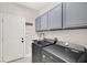 Well-organized laundry room with modern washer and dryer, sink, and built-in cabinets at 1763 Crystal Stream Ave, Henderson, NV 89012