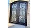 Elaborate wrought iron front door with glass insets and stone brick surround at 1819 Beverly Way, Las Vegas, NV 89104